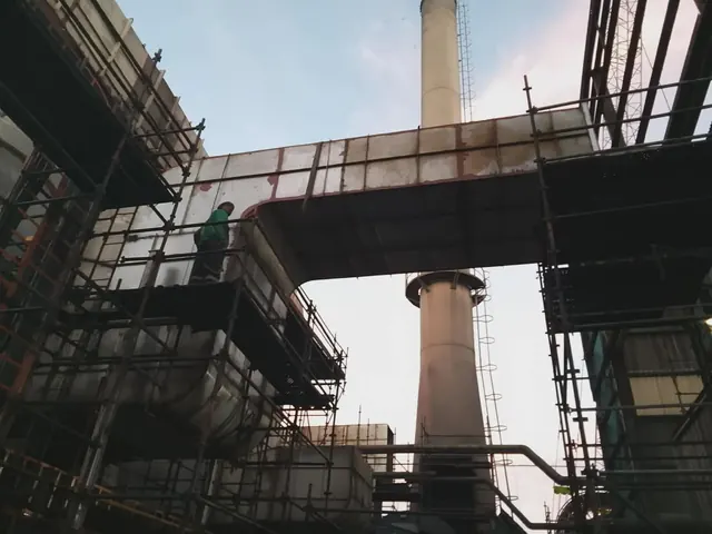 Ductwork erected on scaffolding beside a stack